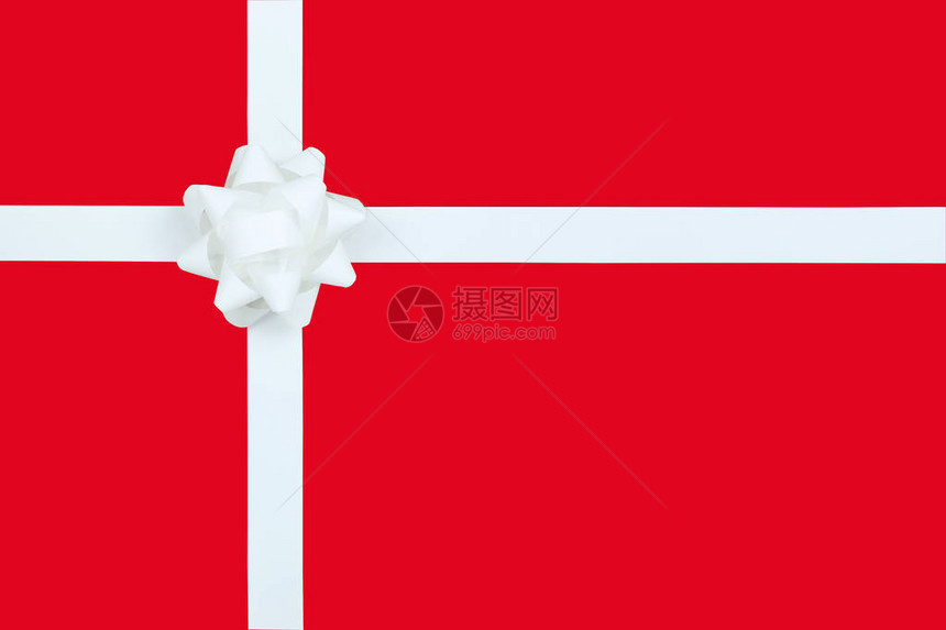 圣诞白弓和红纸背景的彩带特庆节礼物盒图片