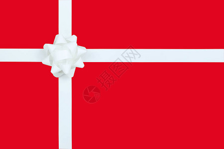 圣诞白弓和红纸背景的彩带特庆节礼物盒图片