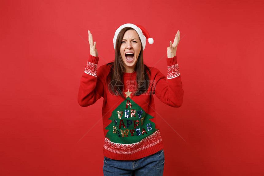 穿着编织毛衣的愤怒不满圣诞老人女孩戴圣诞帽子伸出双手在红色下大喊叫孤立地哭泣图片
