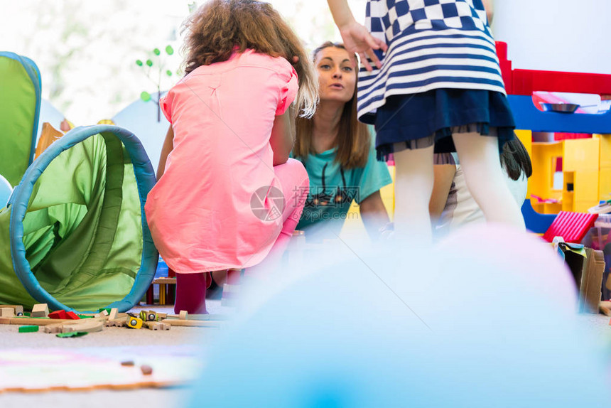 年轻敬业的幼儿园老师在课堂互动游戏时间为孩子们协图片