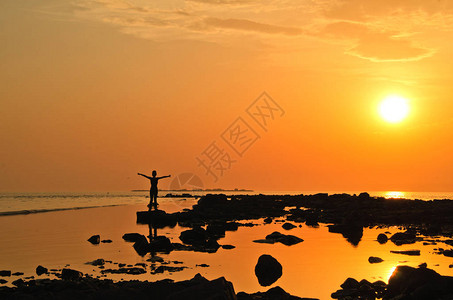 在日落的夜晚沿着夏天的海岸走来去一只女人图片