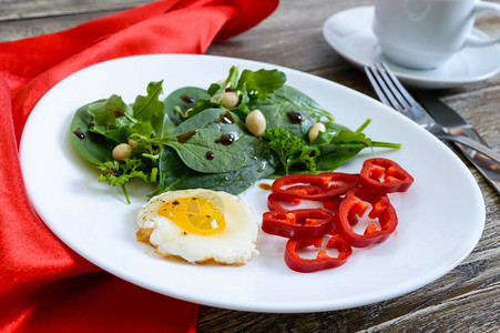 清淡的早餐鹌鹑蛋绿色沙拉甜椒和木桌上的一杯茶健康食品图片