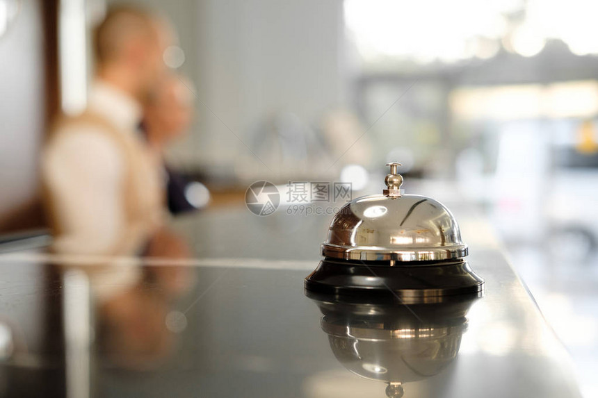 现代豪华酒店接待台与贝尔服务铃位于接待处桌子上的银色呼叫铃图片
