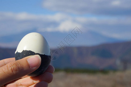 大涌谷男子手在富士火山上展示黑蛋背景