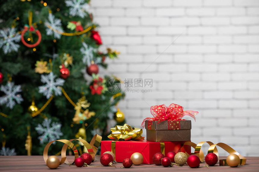 古老的红色和礼品盒装饰着闪亮球圣诞树的柔软模糊背景和白砖墙图片