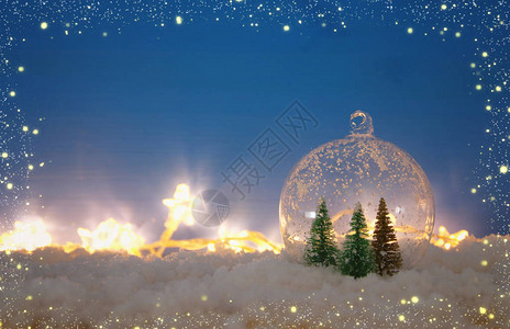 玻璃球中的圣诞树在木制桌上图片