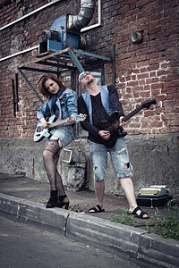 城市街道上的女孩和男孩朋克弹吉他图片