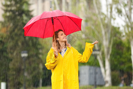 雨天在公园里拿着红伞的快乐图片