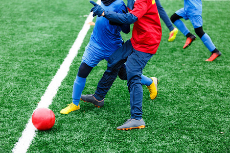 两名年轻的足球员跑步运球和争夺球权少年足球比赛冬季活动足球图片
