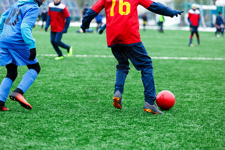 两名年轻的足球运动员跑步运球和争夺球权少年足球比赛冬季活动足球图片
