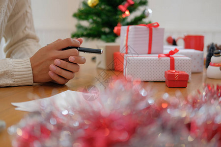 穿着奶油毛衣的男人带着笔记式的思维在新年节庆的圣诞节图片