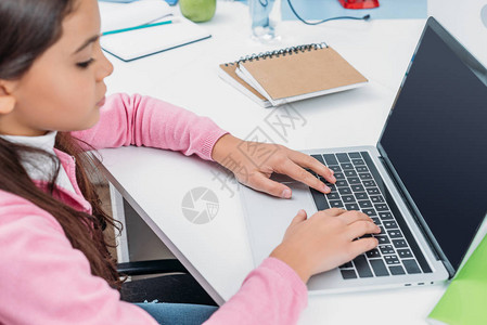 坐在书桌的女中学生在课堂上课时使用带空白屏幕图片