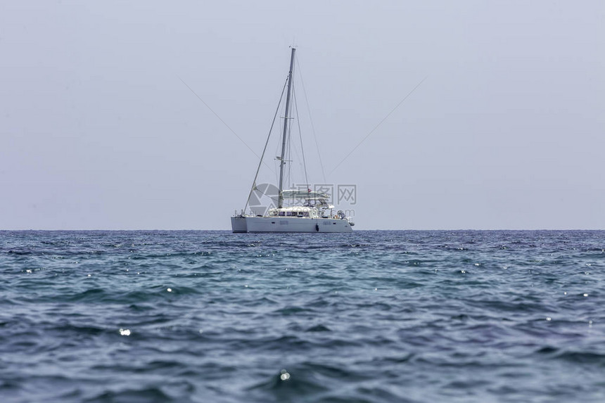 在公海的一艘双体船在地中海的帆船海岸附近的双体船帆双体船帆停靠在热带图片