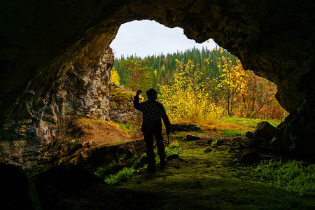 一位地质学家的脚影检查了在洞穴中发现的矿物样本图片