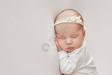 可爱的新生女婴躺在白色的毯子里婴儿用品包装模板新生婴儿的特写肖像图片