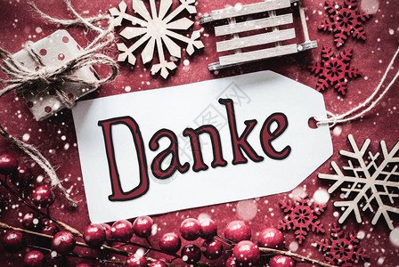 标签与德国书法Danke意味着谢平躺着质朴的红色圣诞装饰图片