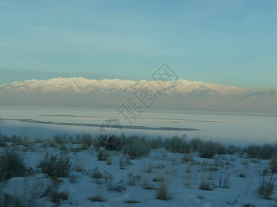 犹他州大盐湖沿岸的白雪皑的土地和远山的景色图片