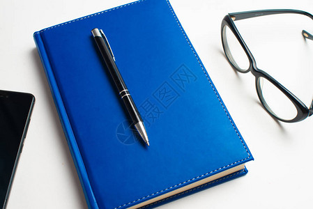 带眼镜和笔的记本带眼镜的书带眼镜的蓝色笔记本带茶杯的书用眼镜和笔工作图片