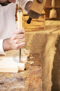 木匠的手在旧木工中加工一块木头图片