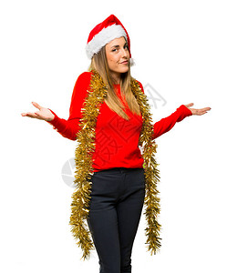 金发女人穿着衣服去过圣诞节做出怀疑姿态却在孤立的白色上图片