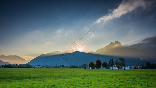 奥地利假日山脉峰后夕阳的体积光束图片
