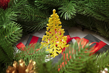 圣诞树有红丝带礼品盒卷木枝和圆锥图片