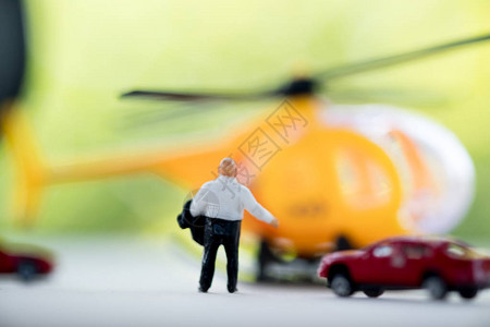 走向直升机的微型商人后视图准备为速度支付直升图片