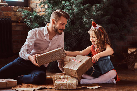 家里的圣诞树旁边有礼物围着他图片
