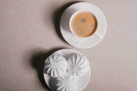 一杯新鲜的咖啡美式咖啡和三个美味的甜点白色棉花糖图片