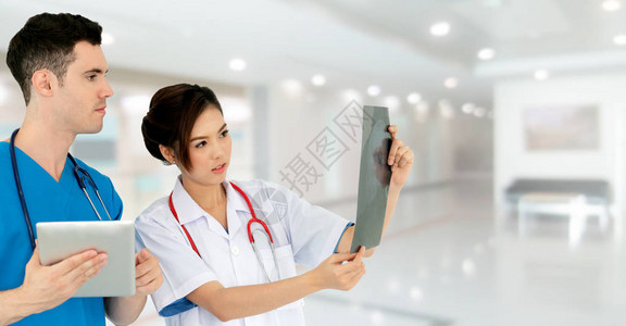 女医生在医院与另一位拿着平板电脑的医生讨论时看着x光片医疗保健人图片