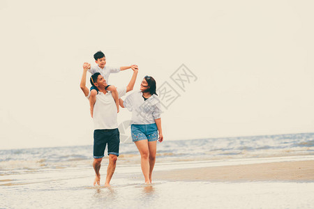 父亲母亲和儿子的幸福家庭暑假在热带沙图片