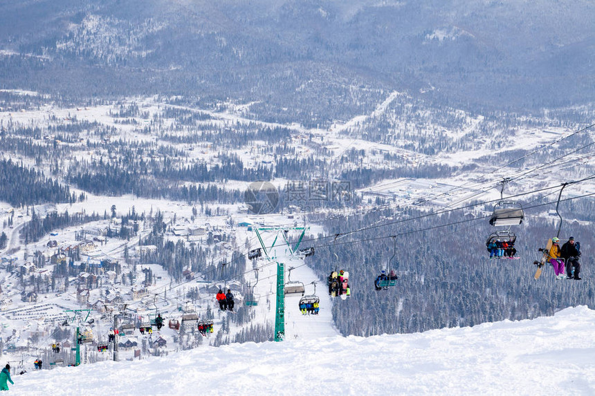 滑雪缆车缆车索道山谷背景的开放式小屋滑雪者滑雪板运动员雪山常青树图片