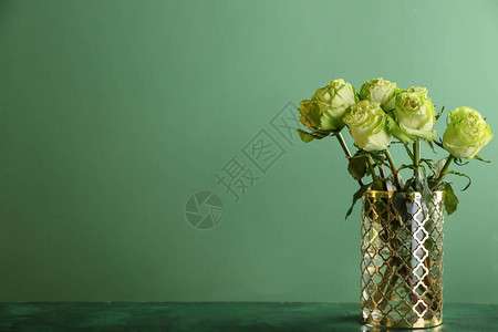 桌边有美丽的花束绿玫瑰花以彩色背景图片