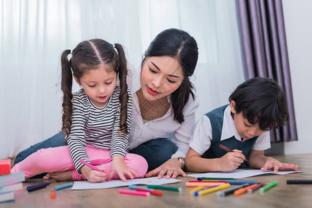 妈在绘画课上教孩子们女儿和子在家里用彩色蜡笔画教师在艺术课堂上培训学生儿童主题的教背景图片