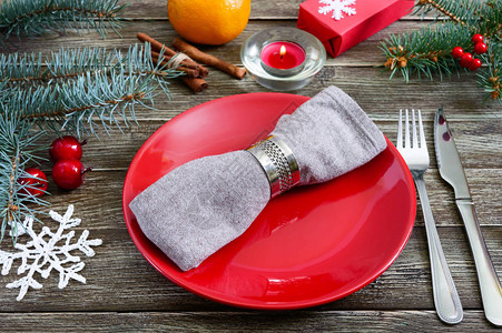 红盘餐巾叉子刀子木桌上的树枝圣诞新年图片