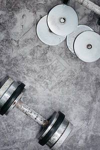 健身或健美概念背景健身房灰色混凝土地板上的旧铁哑铃顶视图图片