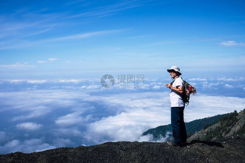 孤独的退休成年白发男子背着包站在徒步旅行冒险中图片