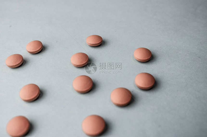小黄橙色美丽的药丸维生素药物蓝色背景的抗生素质地图片