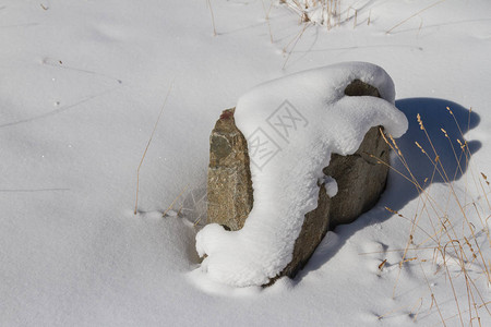 阳光下被雪覆盖的大石头图片
