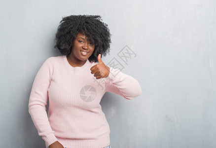 年轻的非洲裔美国大码女人穿着灰色的垃圾墙图片