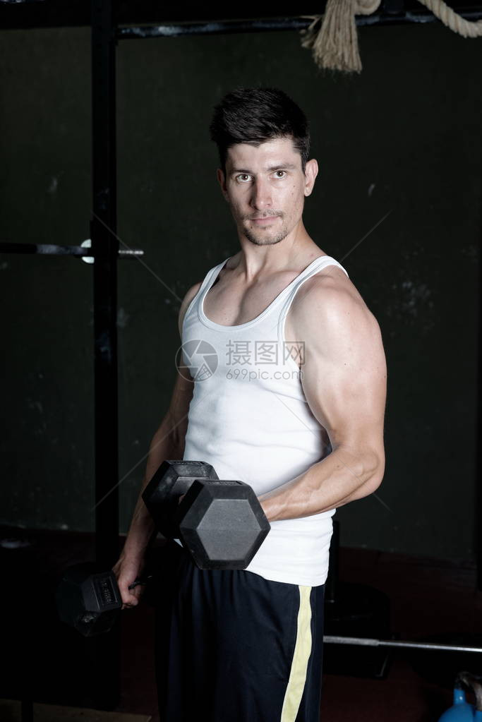 健身教练在健身房训练他的二头肌图片