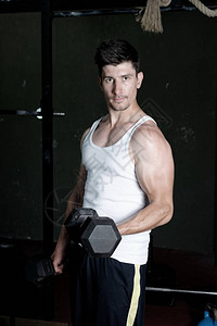 健身教练在健身房训练他的二头肌图片