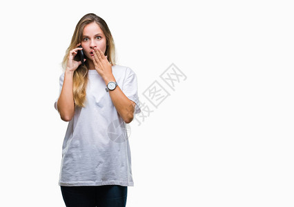 年轻漂亮的金发女郎在孤立的背景上用智能手机打电话图片