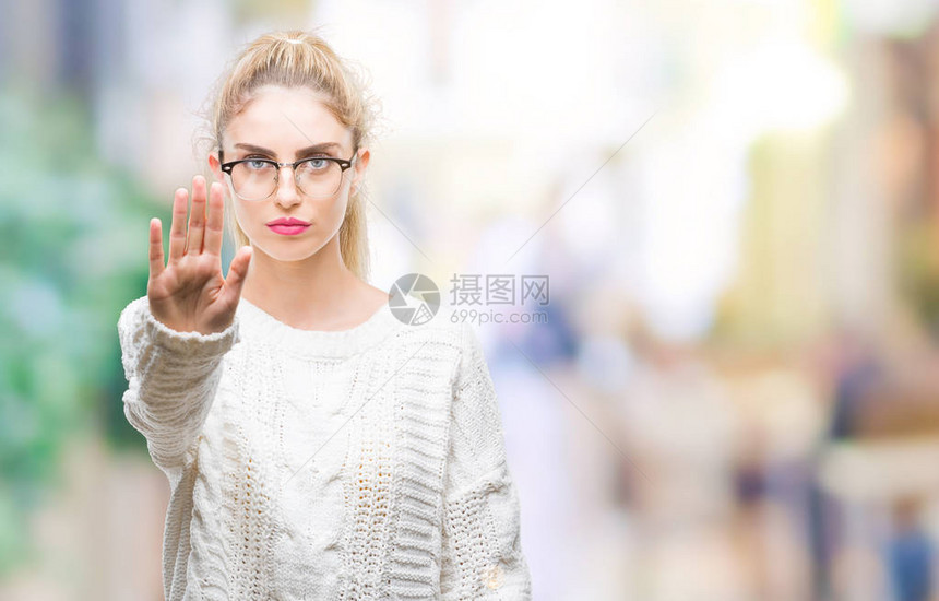 年轻漂亮的金发女郎戴着眼镜在孤立的背景下停止用手掌唱歌脸上带着消极和严肃的图片