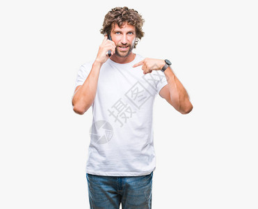 西班牙裔帅哥模特在孤立的背景下用智能手机说话图片