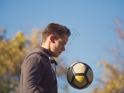 足球选手在日落秋天与足球在图片