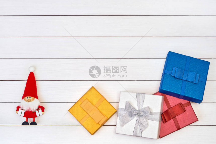 彩色礼品盒和圣诞老人的白木背景顶端视图复制空间图片