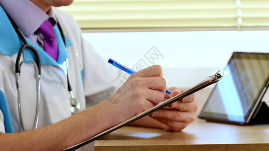 男医师生在剪贴板上为病人写rx处方图片