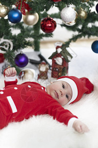 女婴在圣诞节装饰的房间里打扮图片