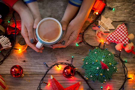 与母亲和孩子一起在节日的圣诞装饰中端着一杯热茶图片